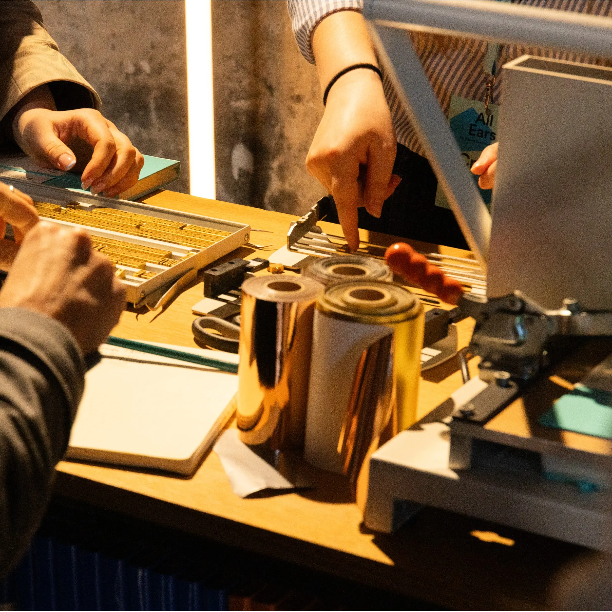 Visitantes seleccionan las letras y preparan el estampado en la máquina de grabado.